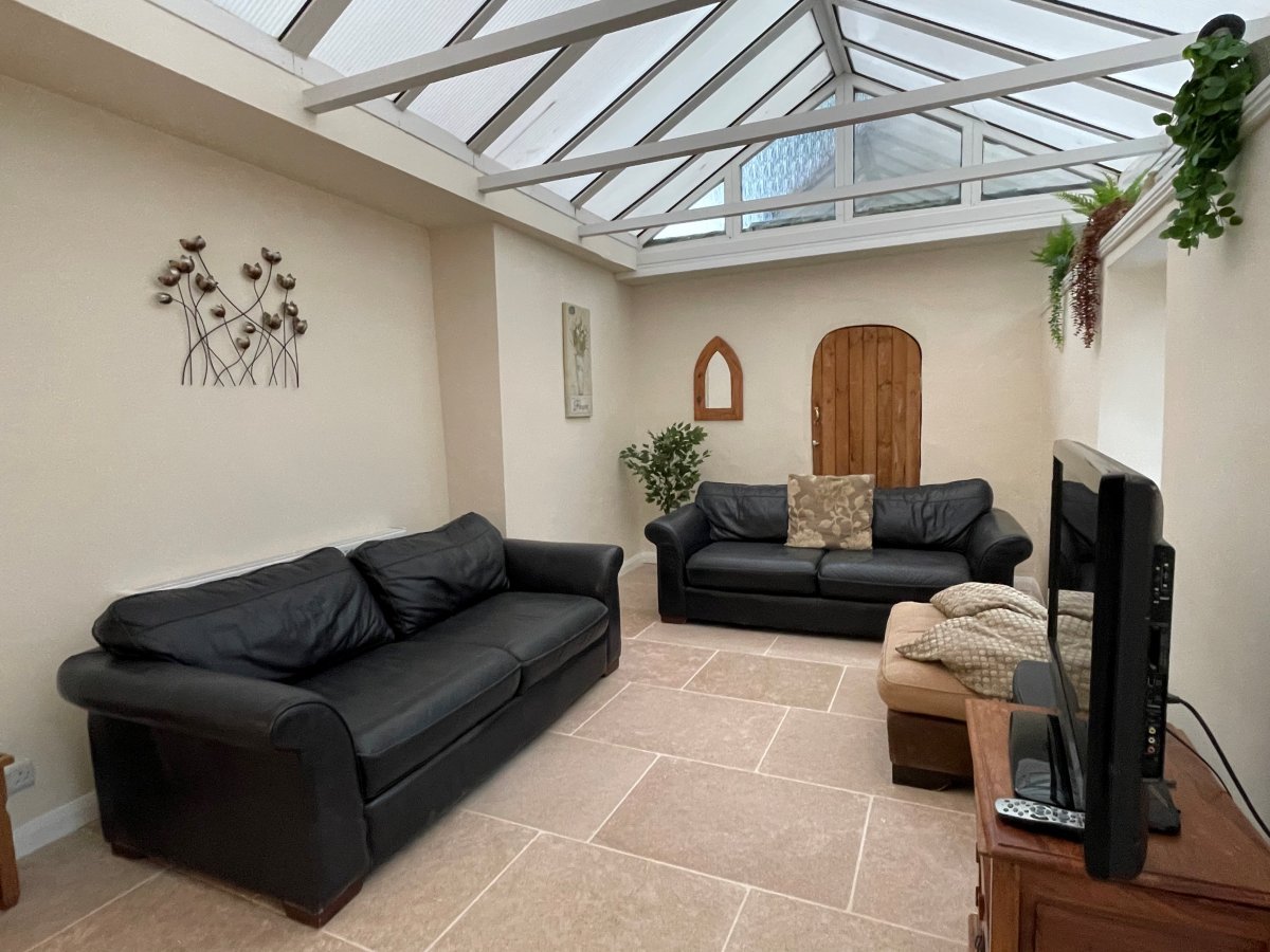 White Roses - conservatory with comfy sofas and TV